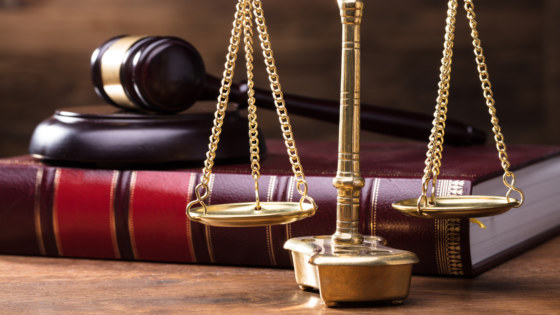Judge Golden Scale In Front Of Gavel And Law Book