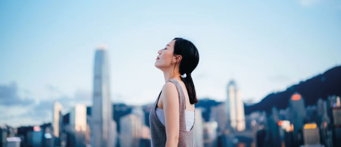 side-profile-of-young-asian-woman-taking-a-deep-breath-with-her-eyes-closed-enjoying-the-fresh-air-a