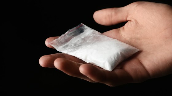 Drug Dealer Holding Bag With Cocaine On Black Background, Closeu